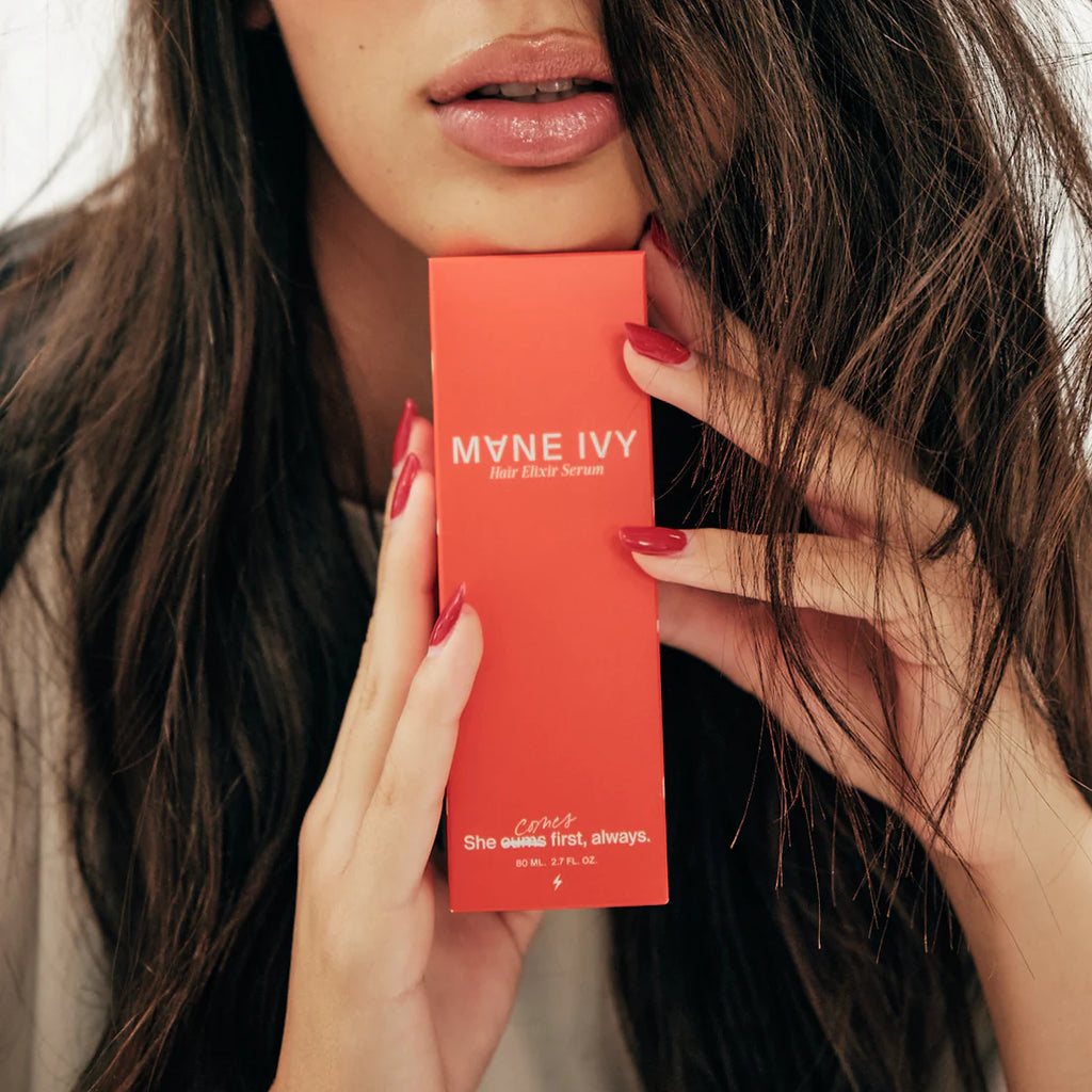 This shows a woman resting her chin on the hair serum box. Her hair looks long and healthy. The serum is meant to moisturize your hair and help with breakage and heat protection. 